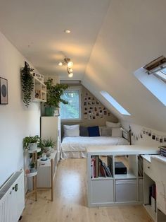 an attic bedroom with white walls and wooden floors, built - in bookshelves