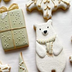 decorated cookies with white frosting and gold trimmings are arranged on a table