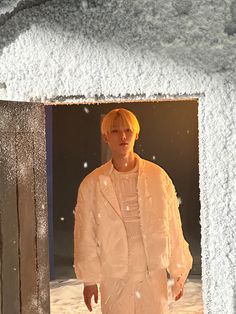 a man standing in front of a snow covered building