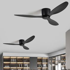 two black ceiling fans are hanging from the ceiling in a room with bookshelves