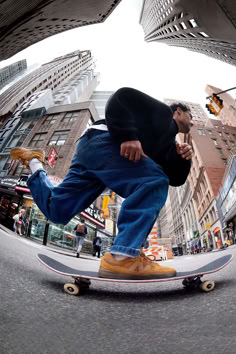 a man riding a skateboard down a street next to tall buildings