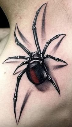 a spider tattoo on the back of a woman's neck with claws and a red ball