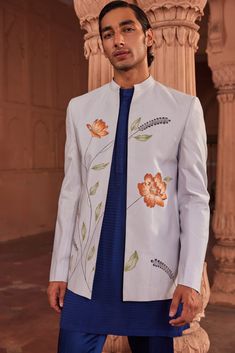 Bagh Jacket Set | Contrast by Parth This exclusive jacket set is a true work of art, featuring hand-painted designs adorned with vibrant floral motifs. The jacket is further elevated with intricate dabka and cutdana embellishments, adding a touch of sparkle and luxury. Paired with a contrast kurta and tailored pants, this ensemble effortlessly combines artistic expression with traditional craftsmanship, making it a standout choice for any special occasion. Included in purchase: Jacket, Kurta and Pants Product Specification Color: Powder Blue Fabric: Pure silk Occasion: Formal Event, Wedding, Bridal, Reception Style: Jacket Set Designer: Contrast by Parth Care: Dry Clean Only Work: Hand Embroidered ( Variation in color, fabric & detail is possible. Model images are only representative.) Thi Spring White Nehru Jacket With Floral Print, Designer Long Sleeve Sets For Spring, Designer Embroidered Sets For Spring, Hand Embroidery Indian, Manpreet Toor, Kurta And Pants, Embroidery Indian, Painted Jacket, Dhoti Pants