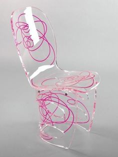 a clear chair with pink swirls on the back and sides, against a gray background