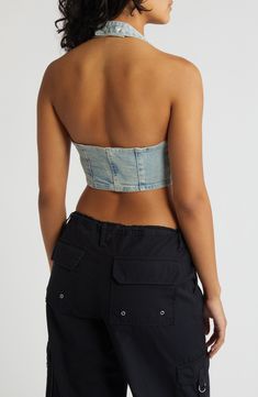 Amp up your edge in this cropped halter top designed in light-wash denim with a zip closure and corset-inspired details. 8 1/2" center front length (size Medium) Front zip closure Halter neck 95% cotton, 4% polyester, 1% spandex Machine wash, line dry Imported Fitted Denim Blue Bandeau Denim Top, Fitted Denim Blue Bandeau Top, Fitted Cropped Denim Tube Top, Trendy Denim Bandeau Crop Top, Cropped Denim Corset For Summer, Light Wash Fitted Denim Crop Top, Fitted Light Wash Denim Crop Top, Fitted Light Wash Cropped Top, Fitted Strapless Denim Crop Top