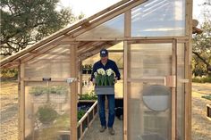 a man standing in a greenhouse holding flowers