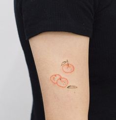 a woman with a tattoo on her arm that has tomatoes and carrots drawn on it