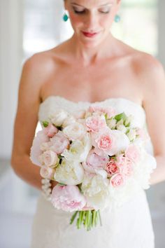 a woman holding a bouquet of flowers in her hands