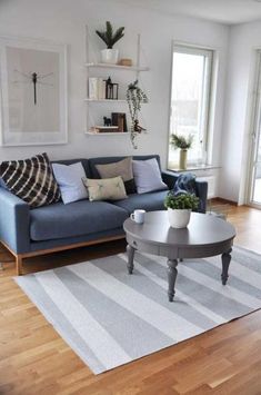 a living room filled with furniture and a rug on top of a hard wood floor