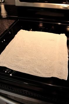 a white towel sitting on top of an oven