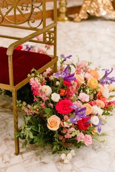 a bouquet of flowers sitting on top of a chair next to a red velvet seat