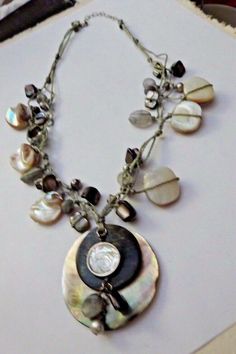 "Silpada Necklace includes shells, sterling silver, quartz, mother of pearl and pearls. Pendant is 2\" long, necklace is 18\" long with a 2\" extender and a lobster clasp. Former display, box not included." Silver Bohemian Pearl Necklace, Silver Mother Of Pearl Shell Necklace, Silver Mother Of Pearl Round Shell Necklace, Silver Round Mother Of Pearl Shell Necklace, Unique Silver Beaded Shell Necklace, Silver Beaded Shell Necklace, Silver Beaded Mother Of Pearl Jewelry, Bohemian Silver Jewelry With Mother Of Pearl, Bohemian Silver Shell Necklace