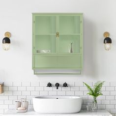 a green cabinet above a white sink in a bathroom