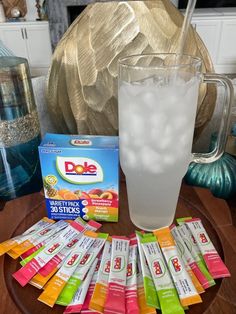 a glass filled with ice sitting on top of a table next to a pile of packets