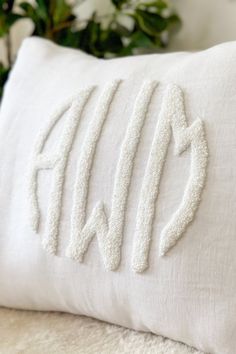 a white pillow with the word monogrammed on it