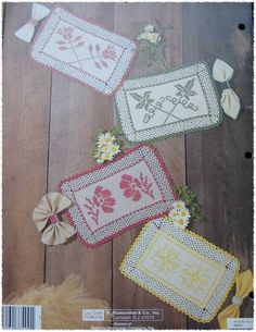 three cross - stitch patterns with flowers and ribbons on the cover of an old book