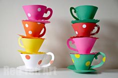 colorful cups stacked on top of each other in front of a white wall with polka dots