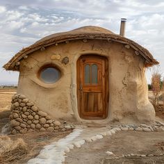 an adobe - style house with round windows and a door in the middle of nowhere