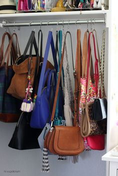 several purses are hanging on a shelf in a closet