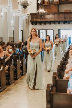 the bridesmaids are walking down the aisle