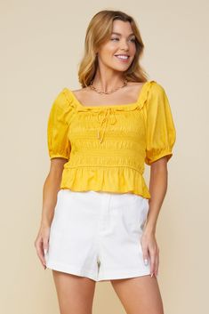 Here comes the sun. Done in a golden yellow shade, this lightweight jacquard top features a smocked bodice, short sleeves, and a ruffle-trimmed square neckline with metal-tipped tie detailing. •Square neckline  •Ruffle trim  •Metal-tipped tie detail  •Short sleeves  •Smocked bodice  Item Number: 44681 Summer Puff Sleeve Top With Ruffles And Square Neck, Summer Ruched Puff Sleeve Top With Square Neck, Fitted Smocked Top With Gathered Square Neckline, Fitted Smocked Top With Square Neck And Gathered Neckline, Fitted Smocked Top With Gathered Neckline For Summer, Summer Puff Sleeve Top With Smocked Bodice, Summer Smocked Bodice Puff Sleeve Top, Summer Peasant Top With Smocked Back And Square Neck, Summer Peasant Top With Square Neck And Smocked Back