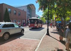 a bus driving down a street next to a crowd of people on the side walk