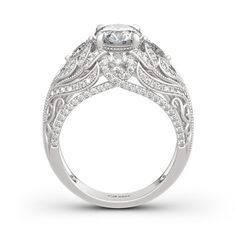 a white gold engagement ring with an intricate design on the band and side stones in the center