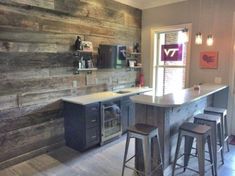 a kitchen with wooden walls and bar stools