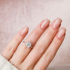 a woman's hand with a diamond ring on it