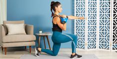 a woman in blue leggings and black top is doing squat exercises on a yoga mat