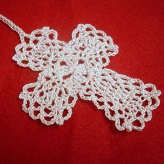 a white crocheted bow on a red surface