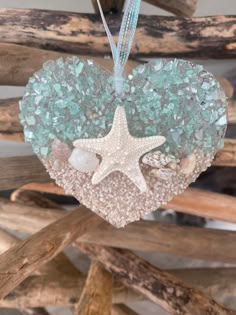 a heart shaped ornament with sea glass and starfish