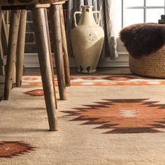 a large rug with an orange and brown design on the floor in front of a window