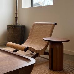 a wooden chair sitting next to a table on top of a carpeted floor in front of a window