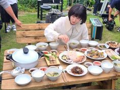 a woman sitting at a table filled with food