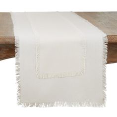 a white table runner with fringes on it