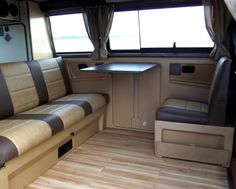 the interior of an rv with wood flooring and tan leather upholstered seats