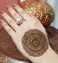 a woman's hand with henna tattoos on it