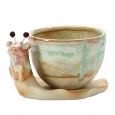 a ceramic cup that has been shaped like a snail with two pins sticking out of it