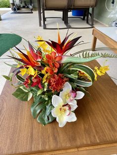 an arrangement of flowers on a table in a living room