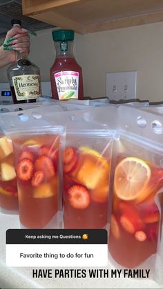 four bags filled with fruit sitting on top of a counter next to a bottle of alcohol