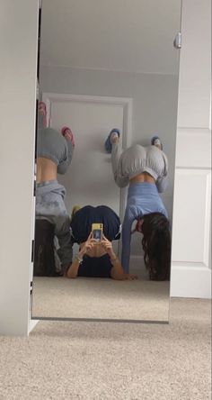 two people are standing in front of a mirror with their feet on the ground and one person is taking a selfie