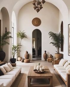 a living room filled with furniture and potted plants