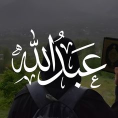 a person with a book in their hand and an arabic writing on the back ground