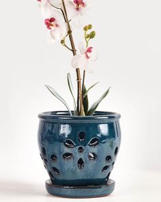 a blue vase with flowers in it on a table