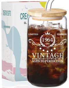 a large glass jar filled with liquid next to a cardboard box that says vintage aged to perfection