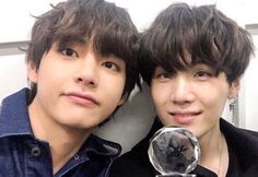 two young men are posing for the camera with their trophies in front of each other