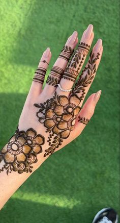 a woman's hand with hennap on it and flowers painted on the palm