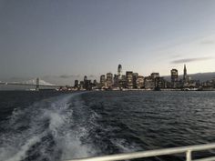 the city skyline is lit up at night as seen from a boat in the water