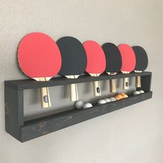 four ping pong paddles are mounted on a wall with five rackets in it